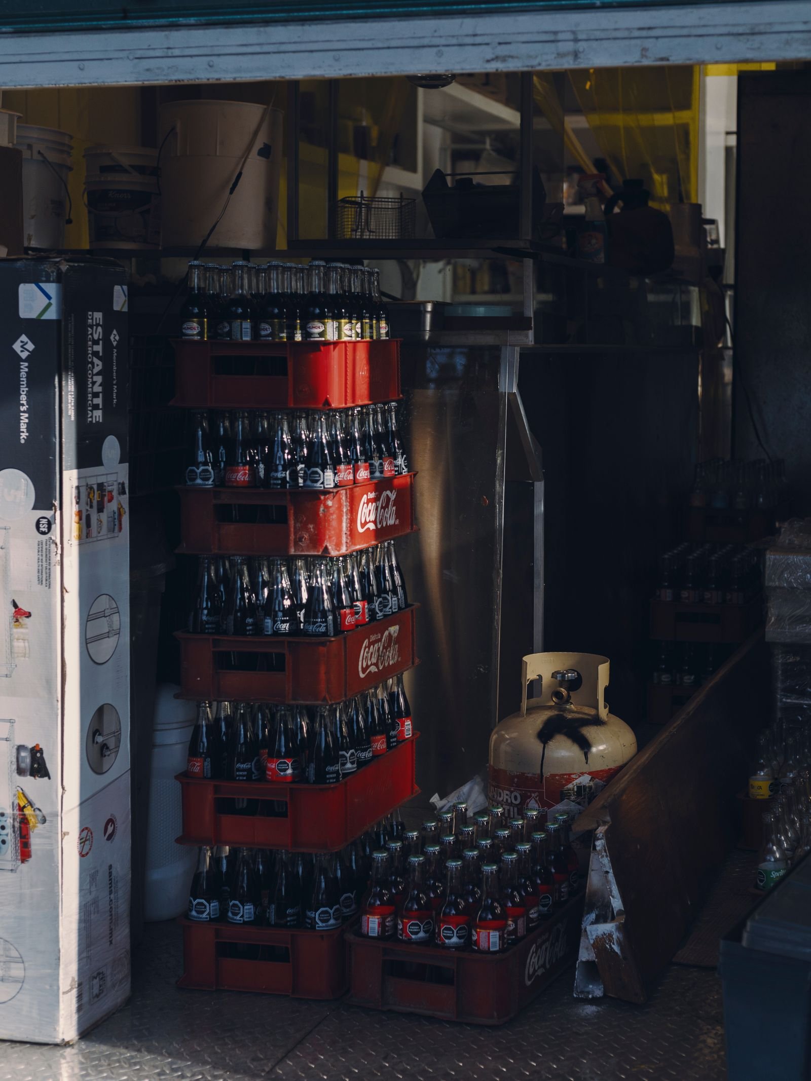 Crates of beverages stacked in a restaurant storage area.