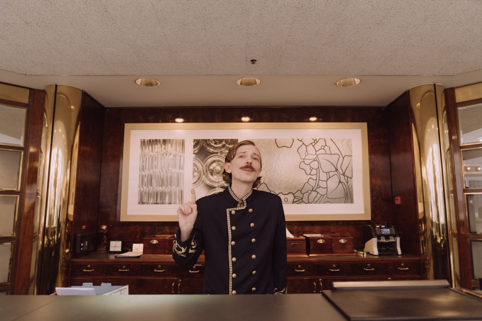 Hotel receptionist in uniform at the front desk.