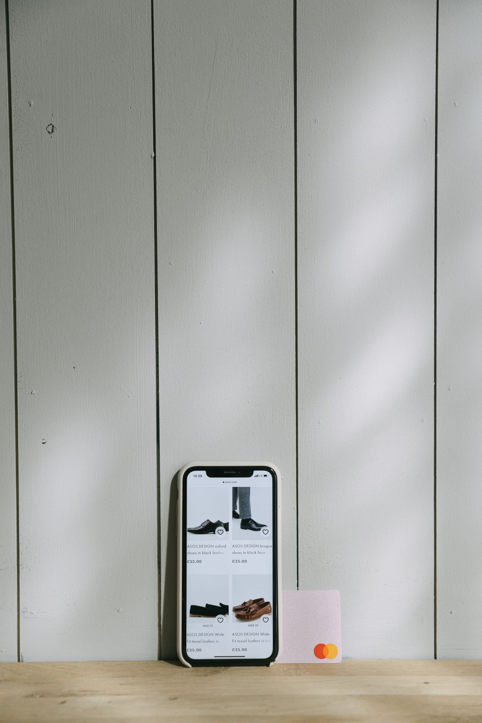 A smartphone displaying a shopping app screen next to a credit card.