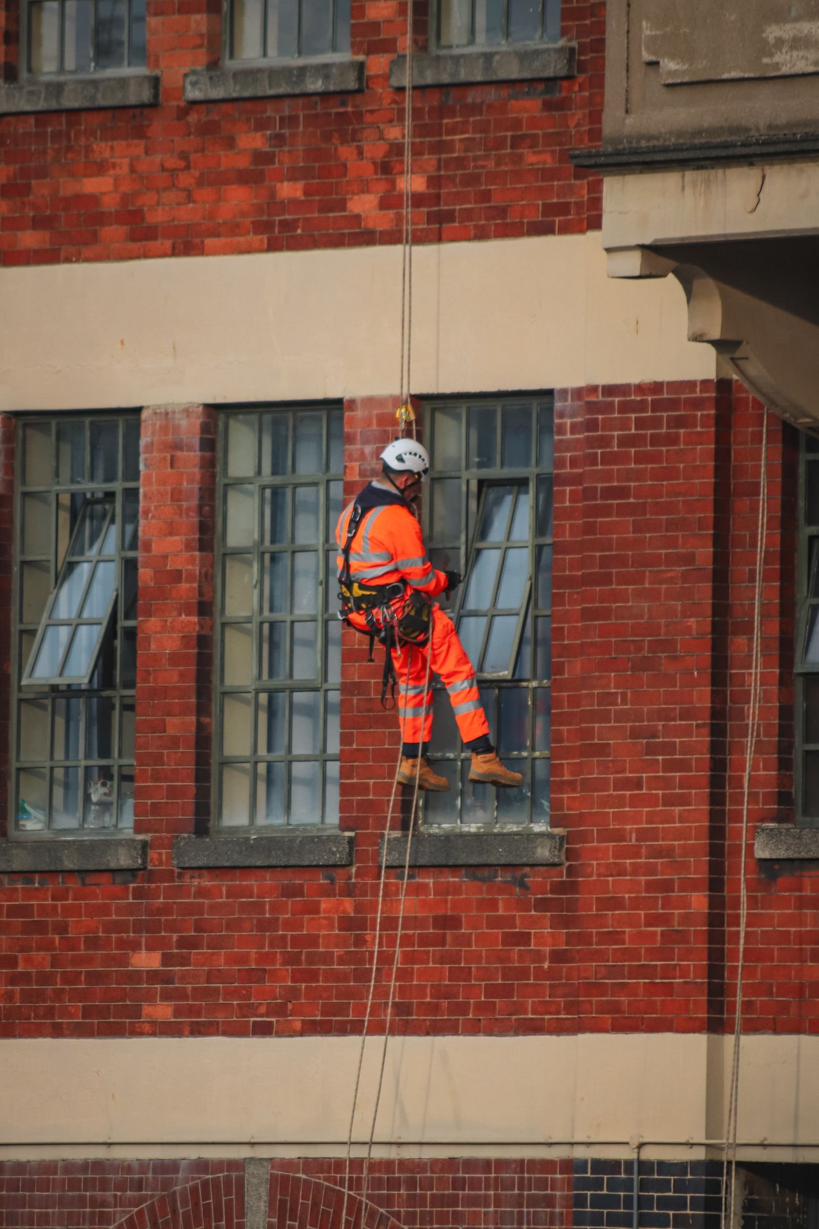 A rope-access technician inspecting a building facade at height.