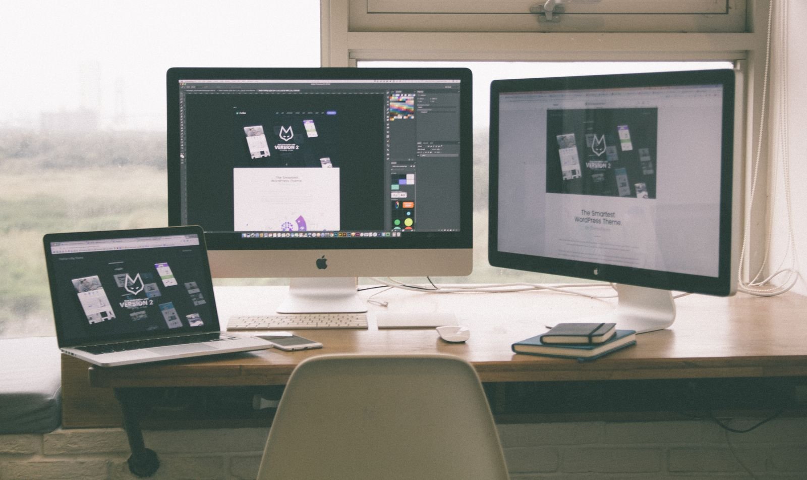 A website design displayed consistently across a laptop and desktop monitors.