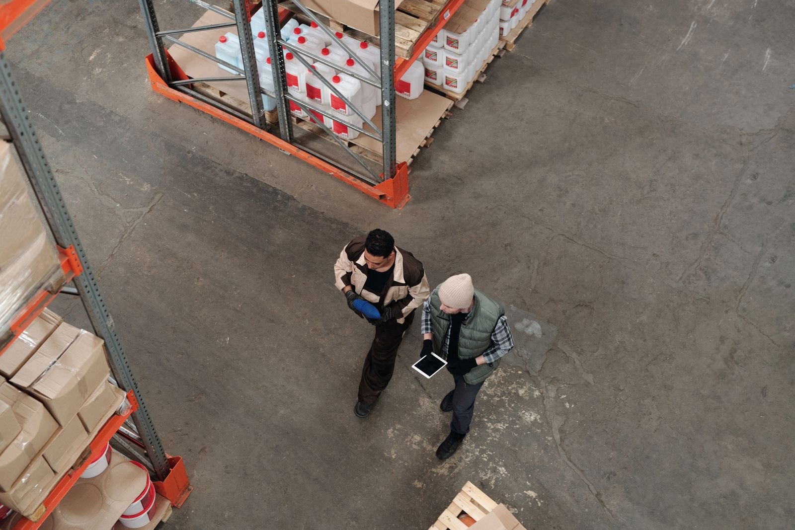 Warehouse staff reviewing a tablet during a stock and dispatch check.