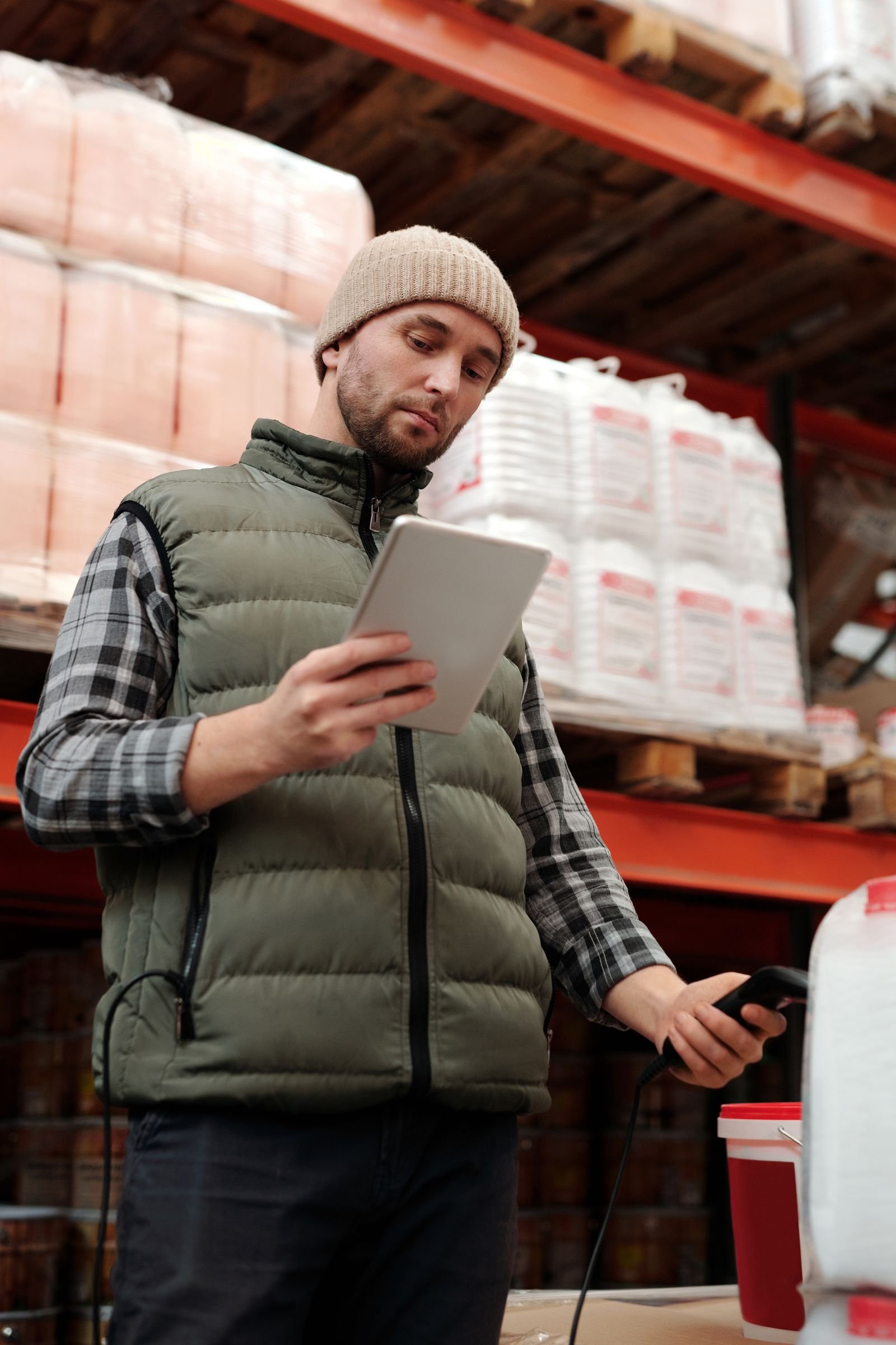 Warehouse worker checking stock levels on a tablet.